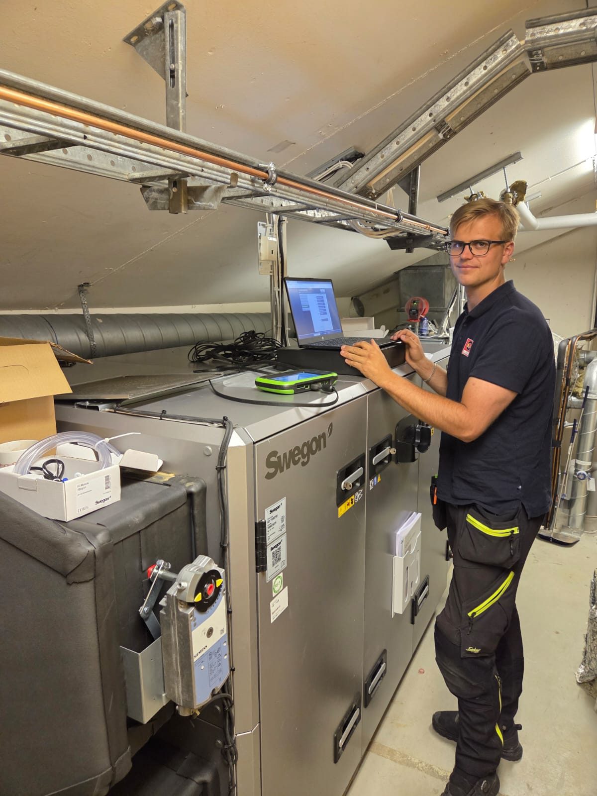 Tekniker som kontrollerar ett ventilationsaggregat