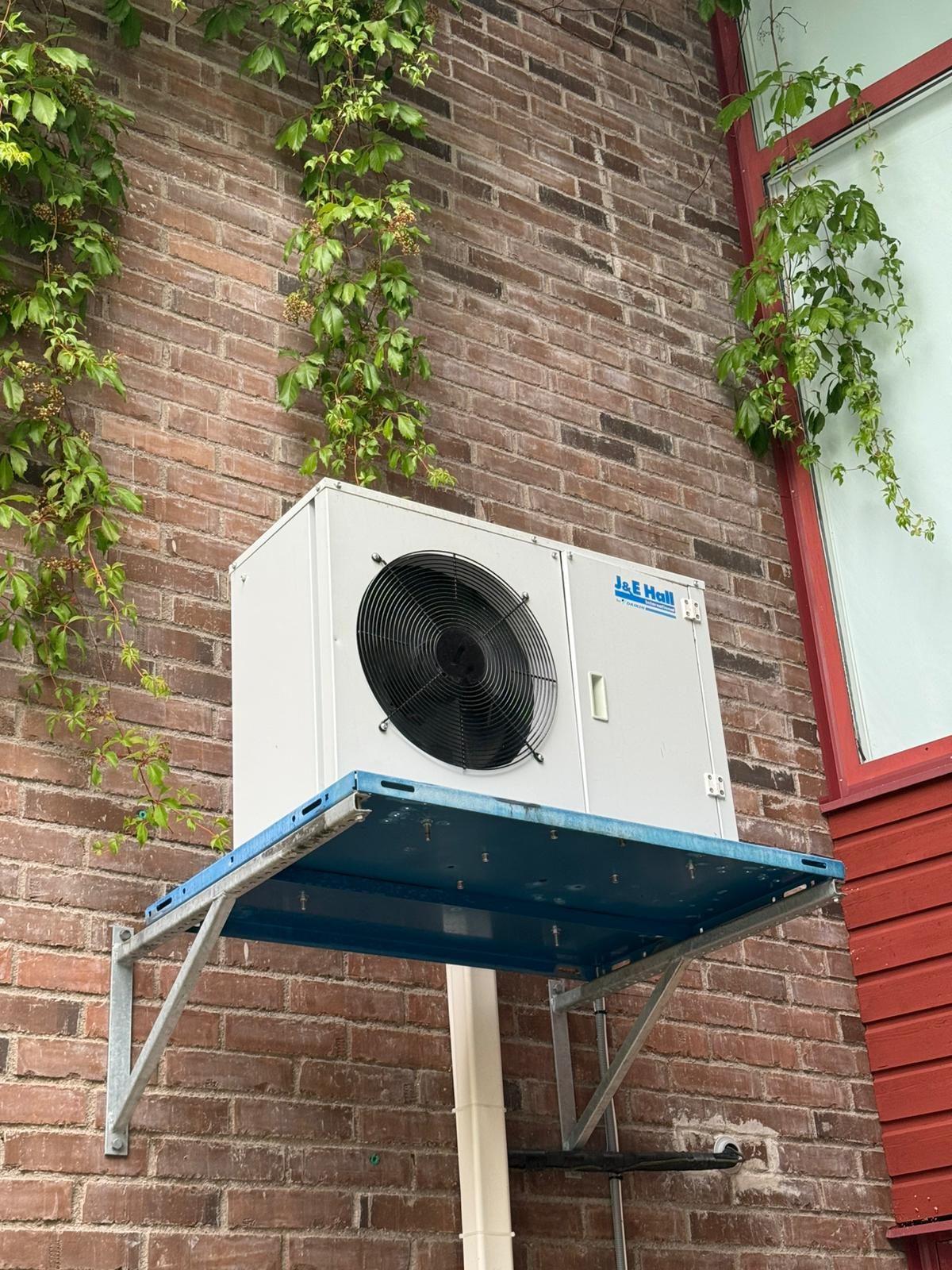 Färdigmonterad värmepump på en tegelfasad